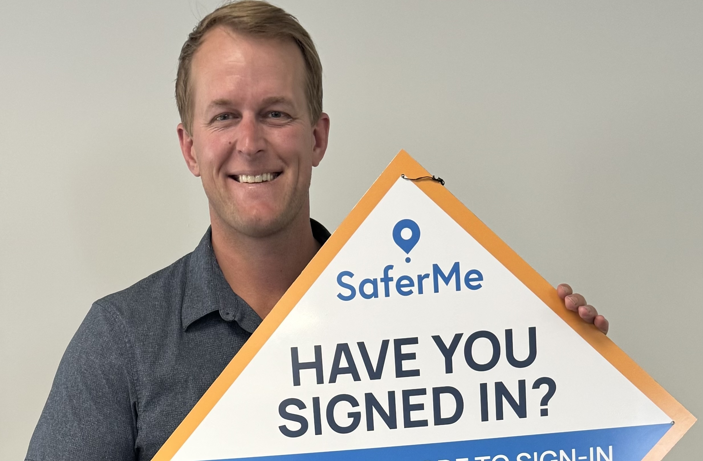 Clint holding a SaferMe sign